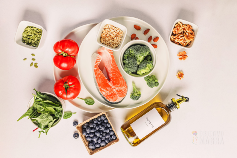 Prato diferente com Alimentação Anti-inflamatória: Emagreça e Alivie Dores como por exemplo: brócolis, uva roxa, azeite, salmão, sementes e folhas verdes escuras.